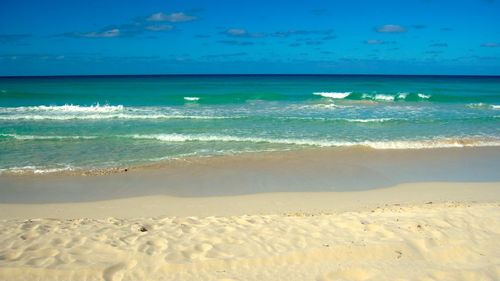 Scenic view of beach against blue sky