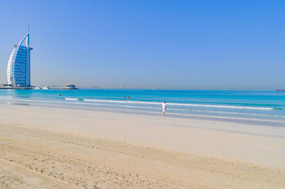 Burj al arab hotel by beach against clear blue sky