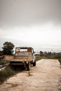 Abandoned truck on road against sky