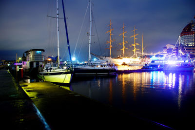 Boats moored in harbor at night