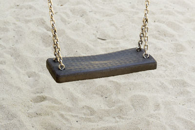 Close-up of swing on sand