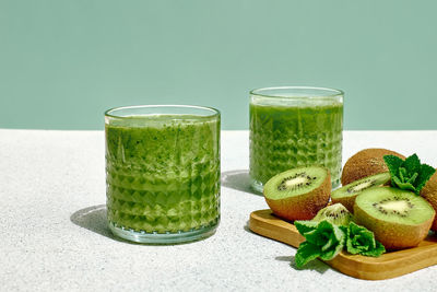 Green smoothie with kiwi fruit in the glasses. healthy organic drink. nutrition and alkaline diet. 