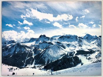 Scenic view of snowcapped mountains against cloudy sky