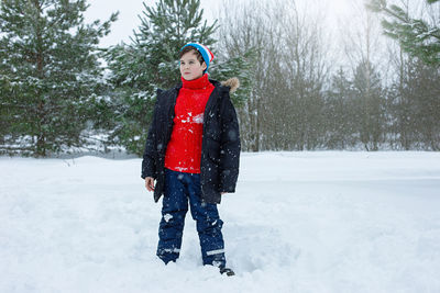 A cute teenage boy in a winter park