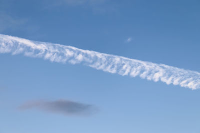 Low angle view of vapor trail against blue sky