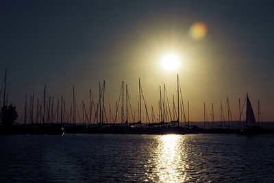 Sailboats in sea against sky during sunset