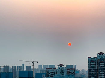 Buildings in city against sky during sunset