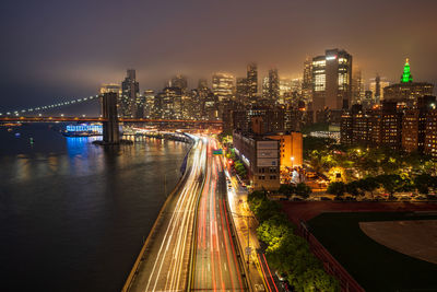 High angle view of illuminated bridge over river in city at night