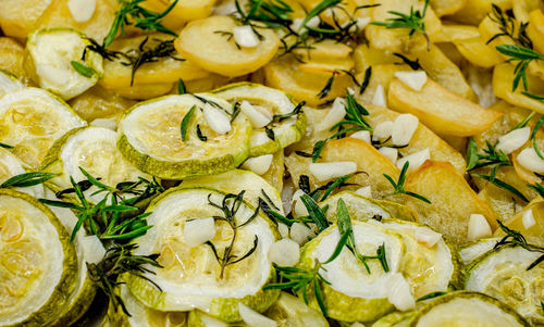 Slices of freshly baked potatoes and zucchini with dill and garlic