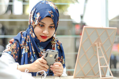 Portrait of young woman photographing