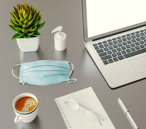 Coffee cup and laptop on table