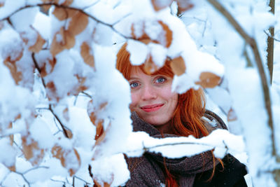 Portrait of smiling young woman standing on snow