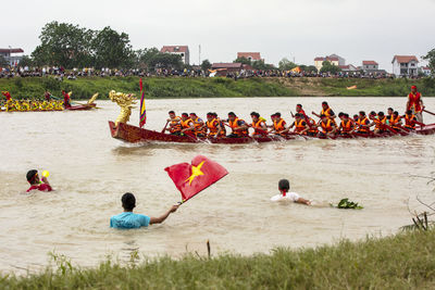 Rear view of people sitting on boat in river