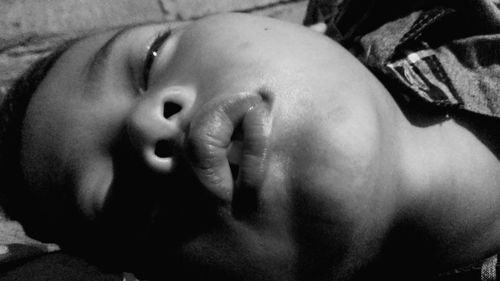 Close-up portrait of cute baby lying on bed