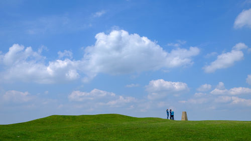 Panoramic view of people on field against sky