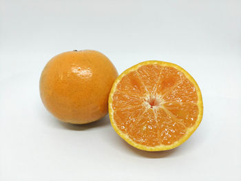 Close-up of orange slices over white background