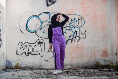 Women standing by graffiti on wall