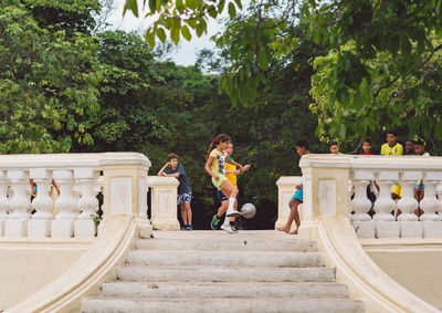 People on staircase by trees