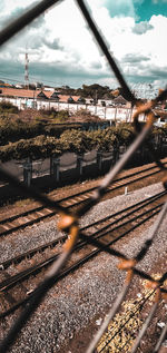 Railroad tracks seen through chainlink fence