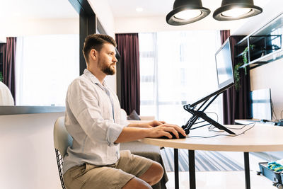 Side view of a man working on table