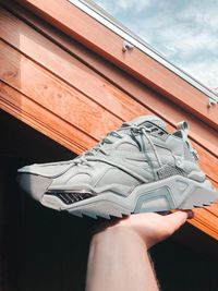 Midsection of person holding umbrella against window