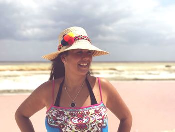 Woman wearing hat against sky at beach