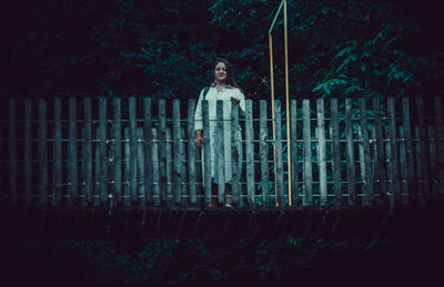 Portrait of teenage girl standing against trees in forest