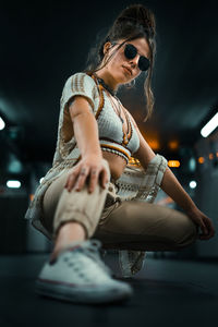 Young woman wearing sunglasses sitting outdoors