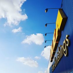 Low angle view of road sign against blue sky