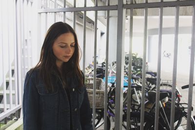 Young woman standing by gate