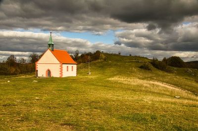 Traditional building on field against sky