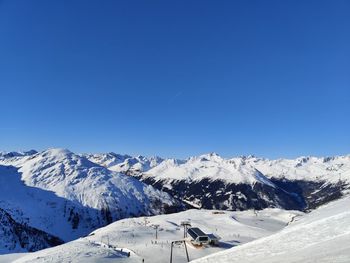 Scenic view of snowcapped mountains against clear blue sky