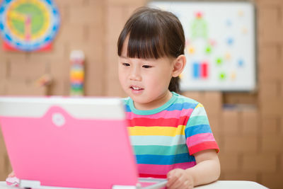 Portrait of cute girl sitting on table