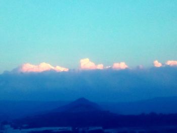 Scenic view of mountains against blue sky