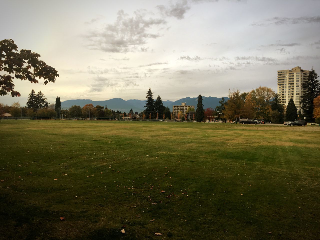 landscape, tranquil scene, tree, building exterior, sky, field, tranquility, scenics, green color, mountain, grassy, outdoors, distant, no people, cloud - sky, residential district, mountain range, beauty in nature, solitude, remote