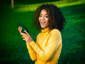 Smiling young woman using smart phone outdoors