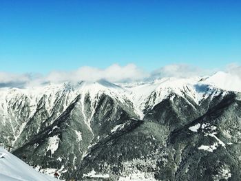 Snow covered mountains against blue sky