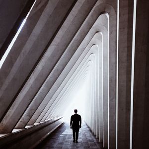 Rear view of people walking in tunnel