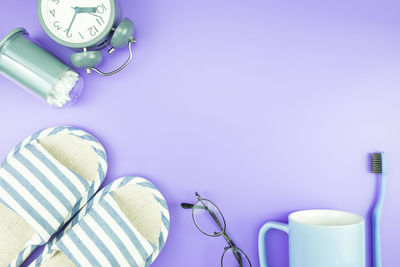 High angle view of personal accessories over purple background