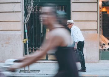 Blurred motion of man walking on road in city