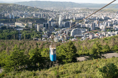 Panoramic view of tbilisi town from mountain, georgia. old blue cable car cabin above the town.