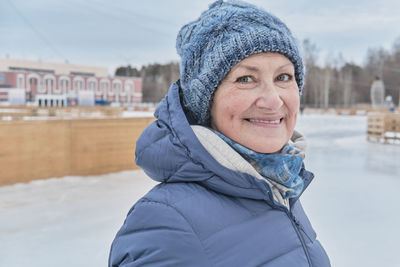 Portrait of smiling young woman standing in snow