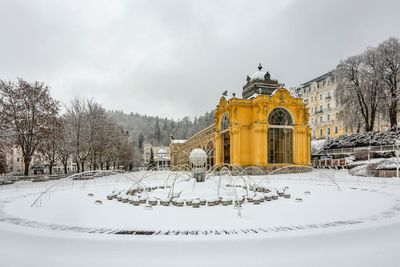 Snow covered buildings against sky