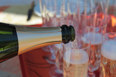 Close-up of champagne pouring from bottle in glass 