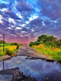 Scenic view of river against cloudy sky