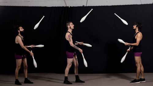 Men juggling while standing at stage