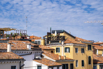 Rooftops of old residential buildings with windows against sky