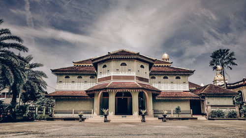 Facade of building against cloudy sky