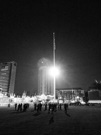 People standing on illuminated city at night