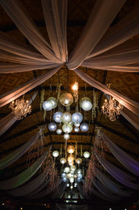 Low angle view of illuminated chandelier hanging from ceiling